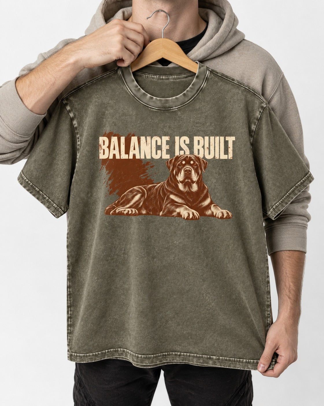 Rottweiler Balance Is Built Resting Strength Graphic Washed Tee in Army Green, held up on a hanger