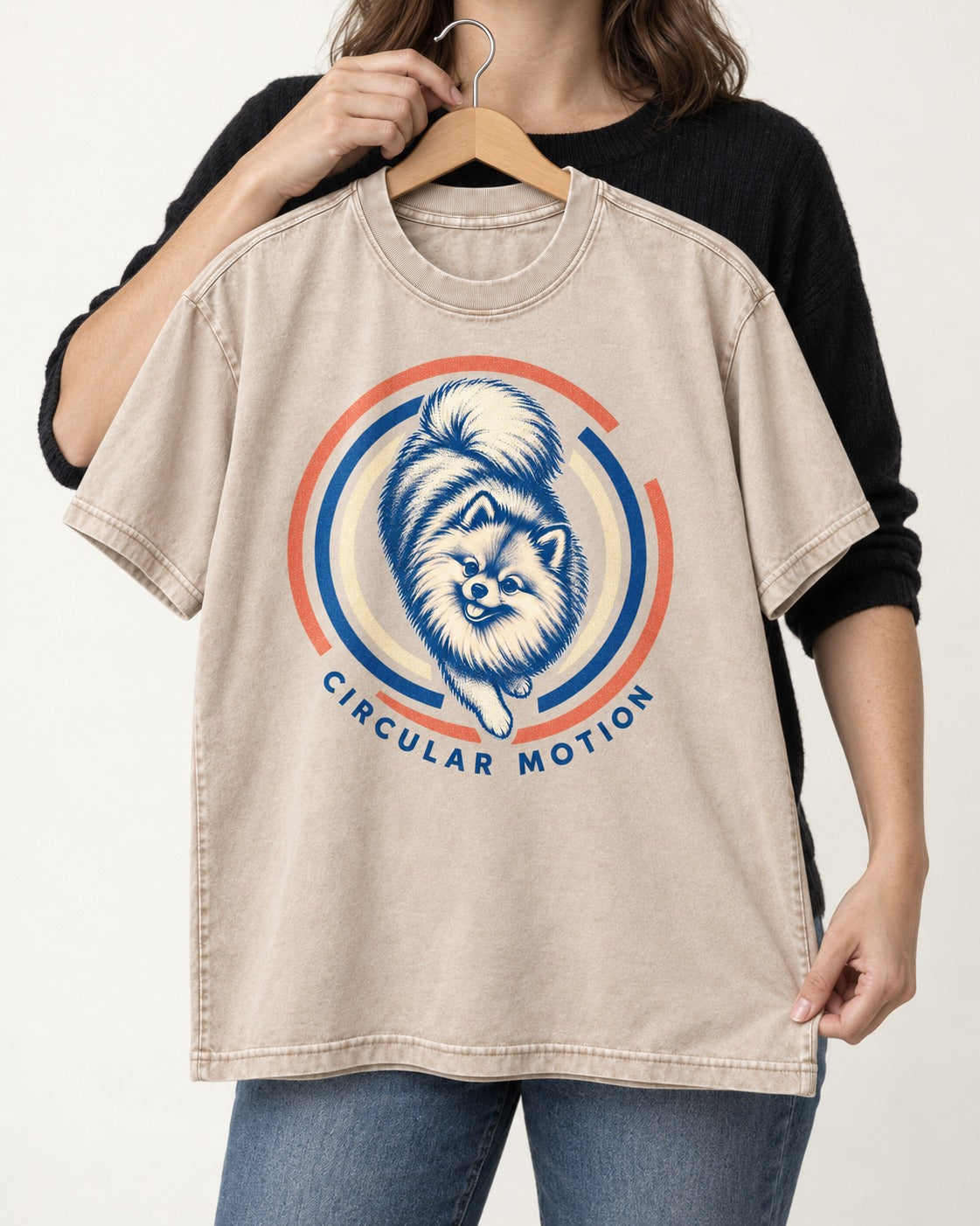 Pomeranian Circular Motion Washed Tee in Apricot, held up on a hanger