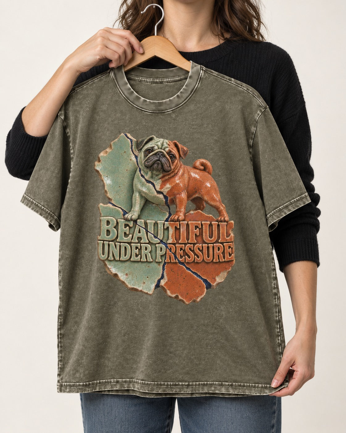 Pug Beautiful Under Pressure Cracked Ceramic Graphic Washed Tee in Army Green, held up on a hanger