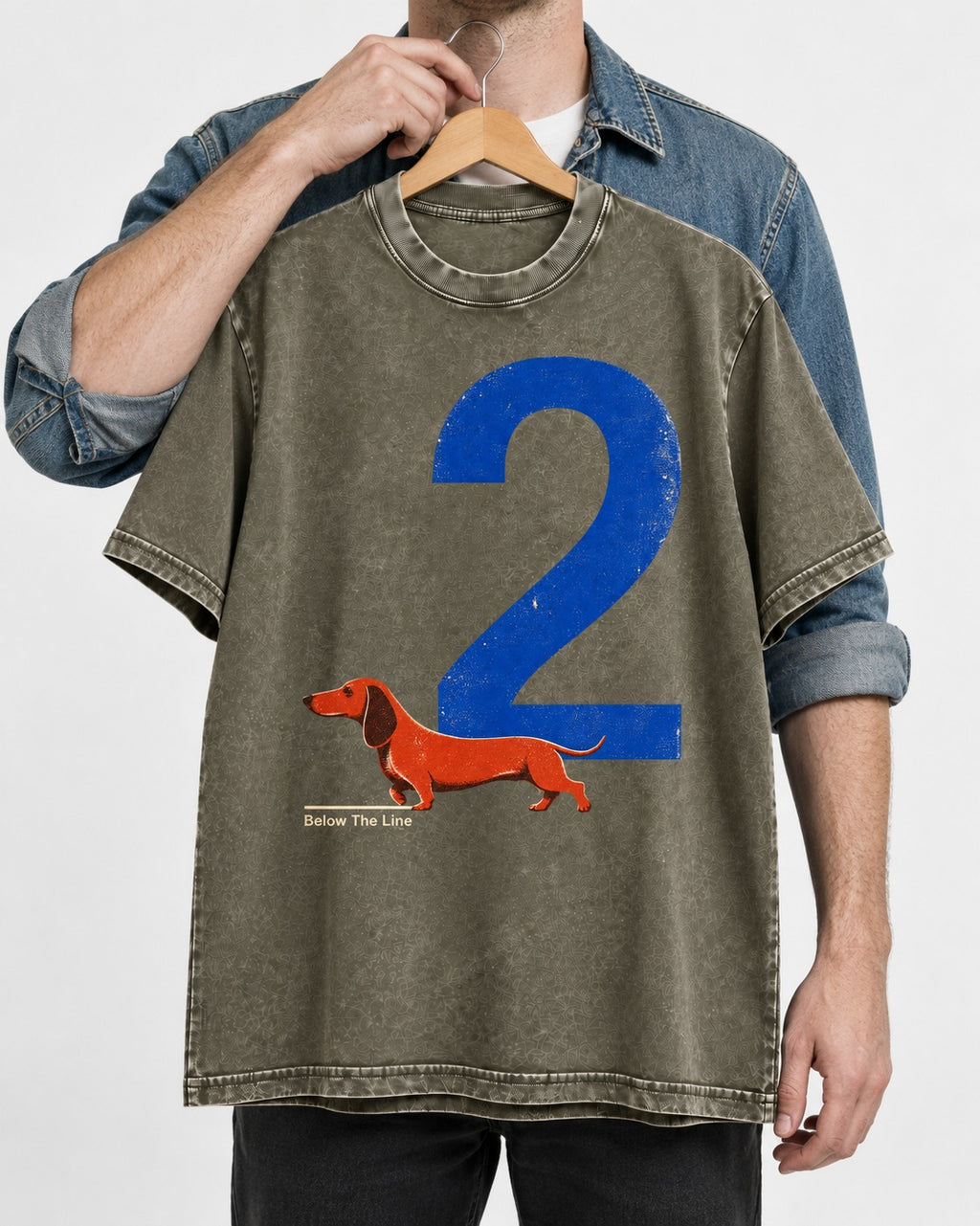 Dachshund Below The Line Number Two Graphic Washed Tee in Army Green, held up on a hanger
