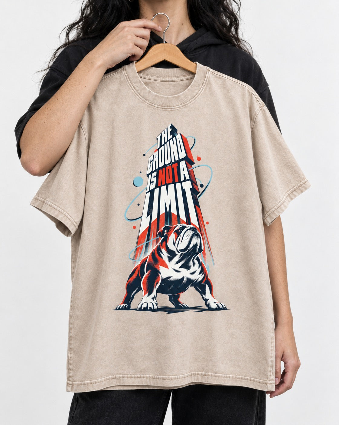 English Bulldog The Ground Is Not a Limit Orbital Graphic Washed Tee in Apricot, held up on a hanger