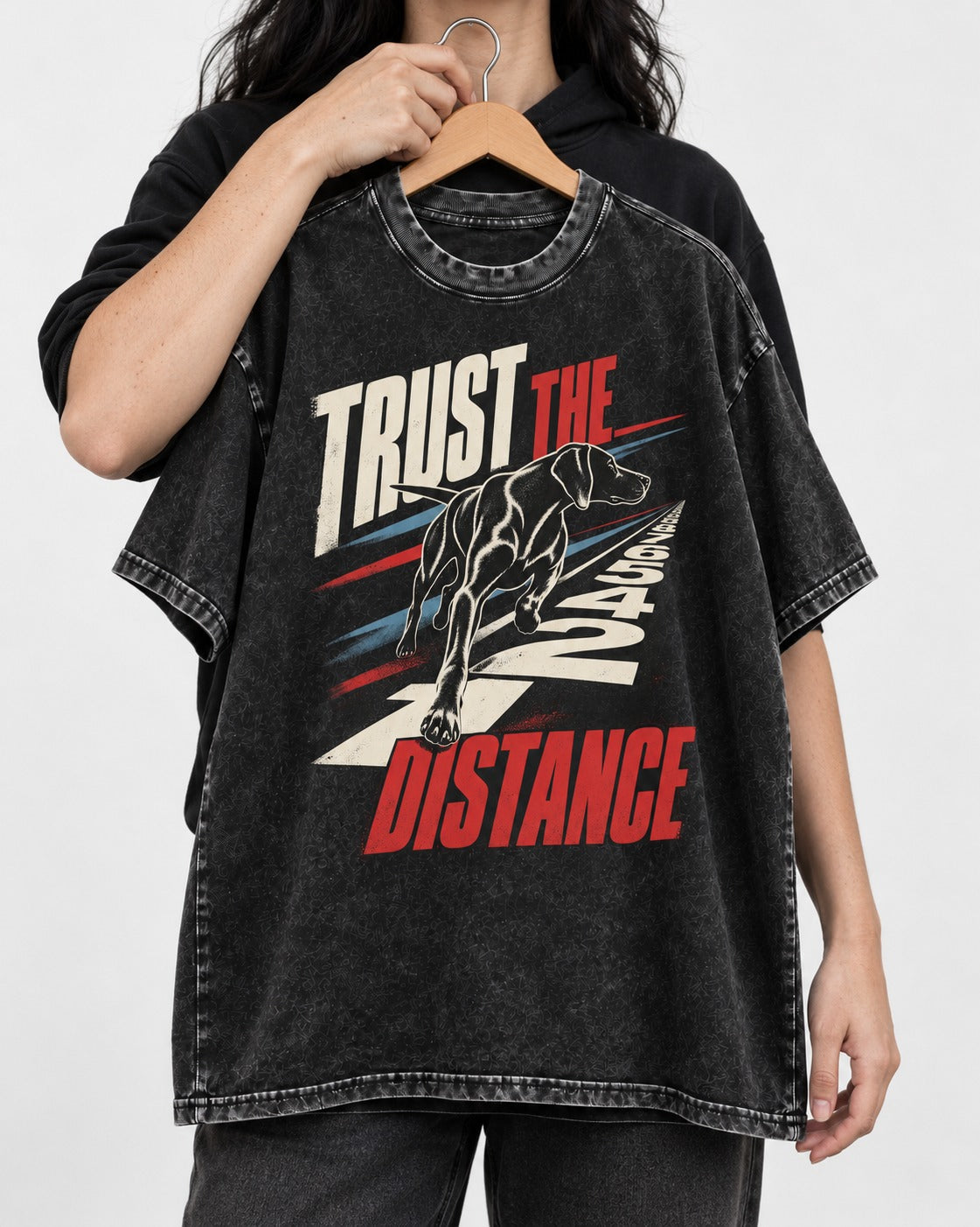 Trust the Distance German Shorthaired Pointer Graphic Washed Tee in Black, held up on a hanger