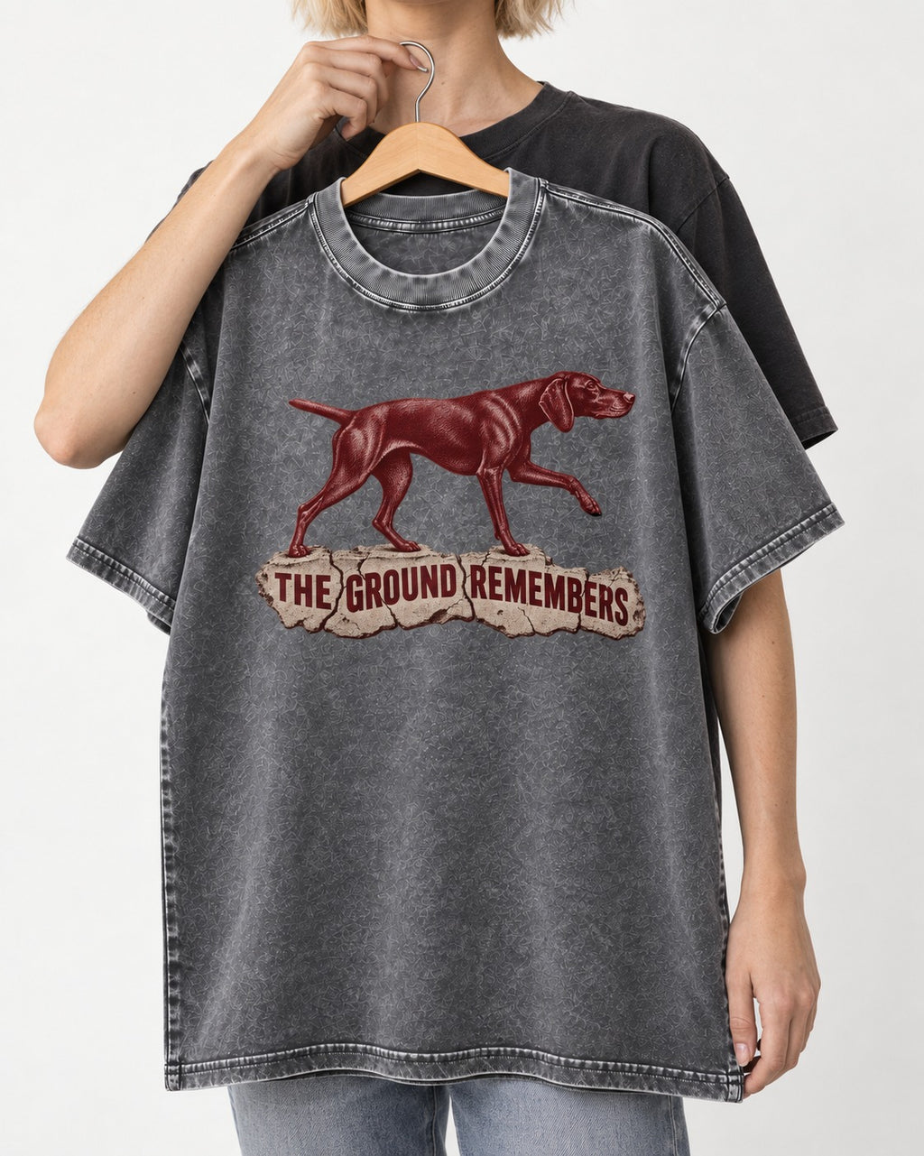 The Ground Remembers German Shorthaired Pointer Washed Tee in Gray, held up on a hanger
