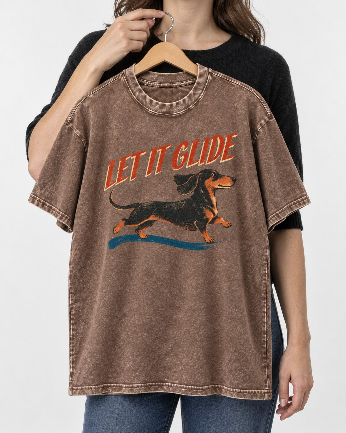 Let It Glide Dachshund Washed Tee in Coffee, held up on a hanger