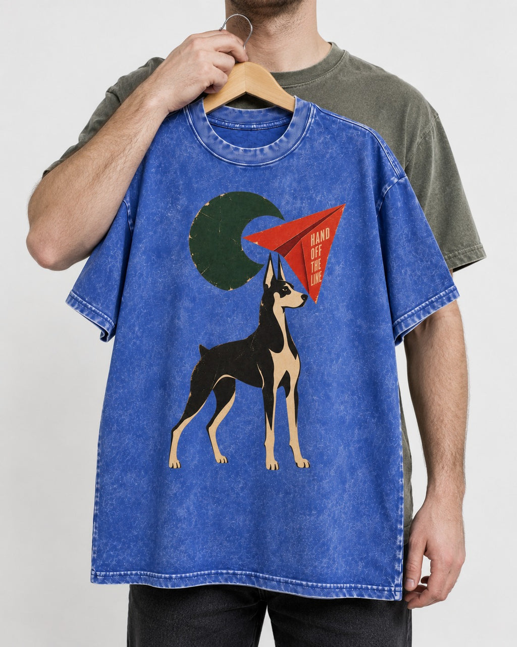 Doberman Hand Off the Line Paper Plane Graphic Washed Tee in Royal Blue, held up on a hanger