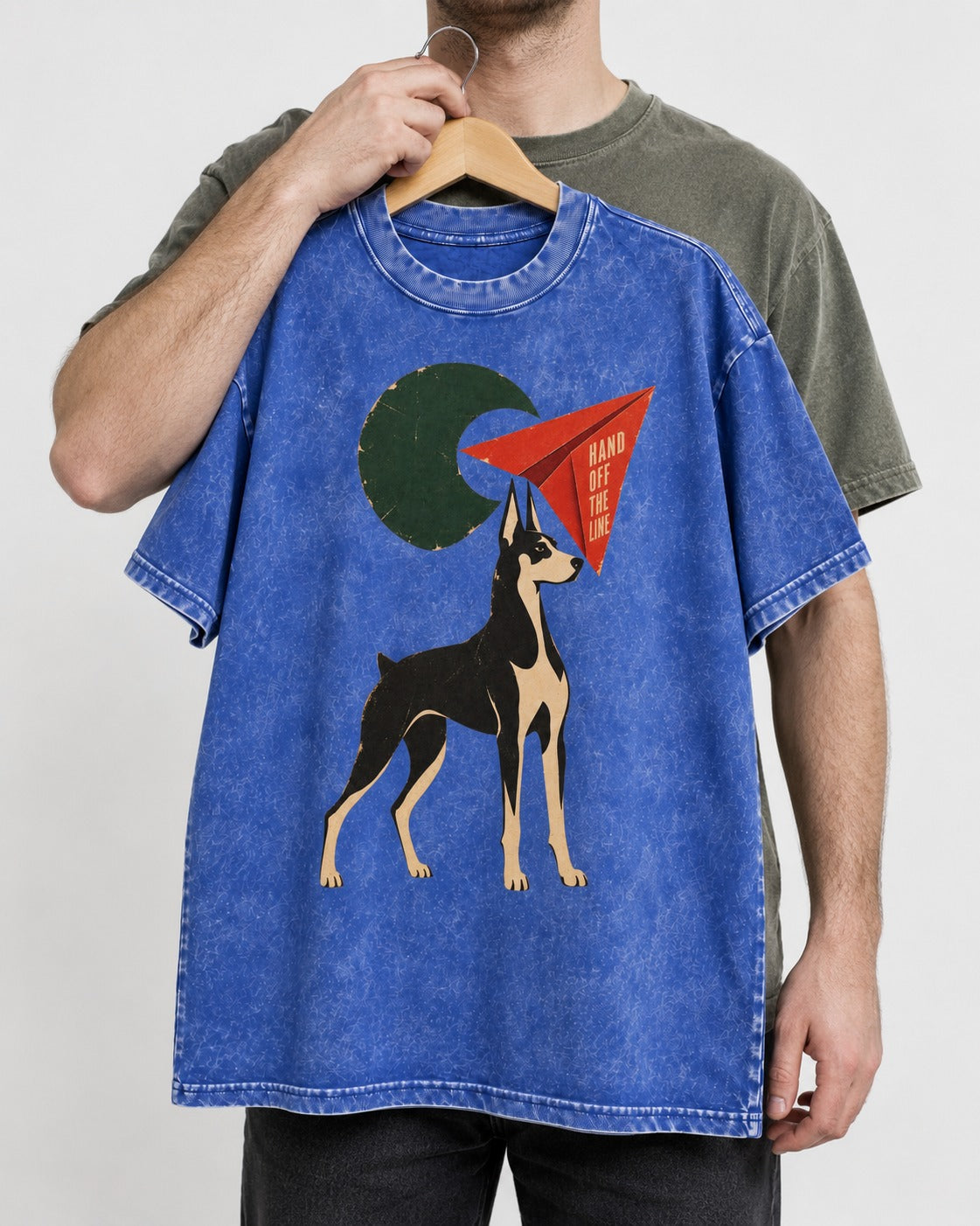 Doberman Hand Off the Line Paper Plane Graphic Washed Tee in Royal Blue, held up on a hanger