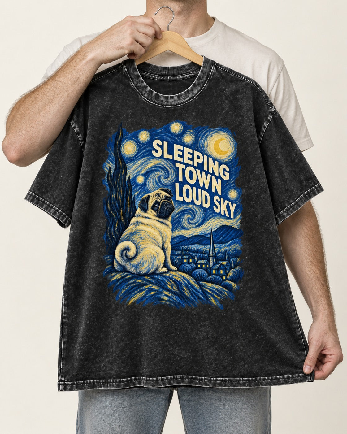 Pug Sleeping Town Loud Sky Starry Night Graphic Washed Tee in Black, held up on a hanger