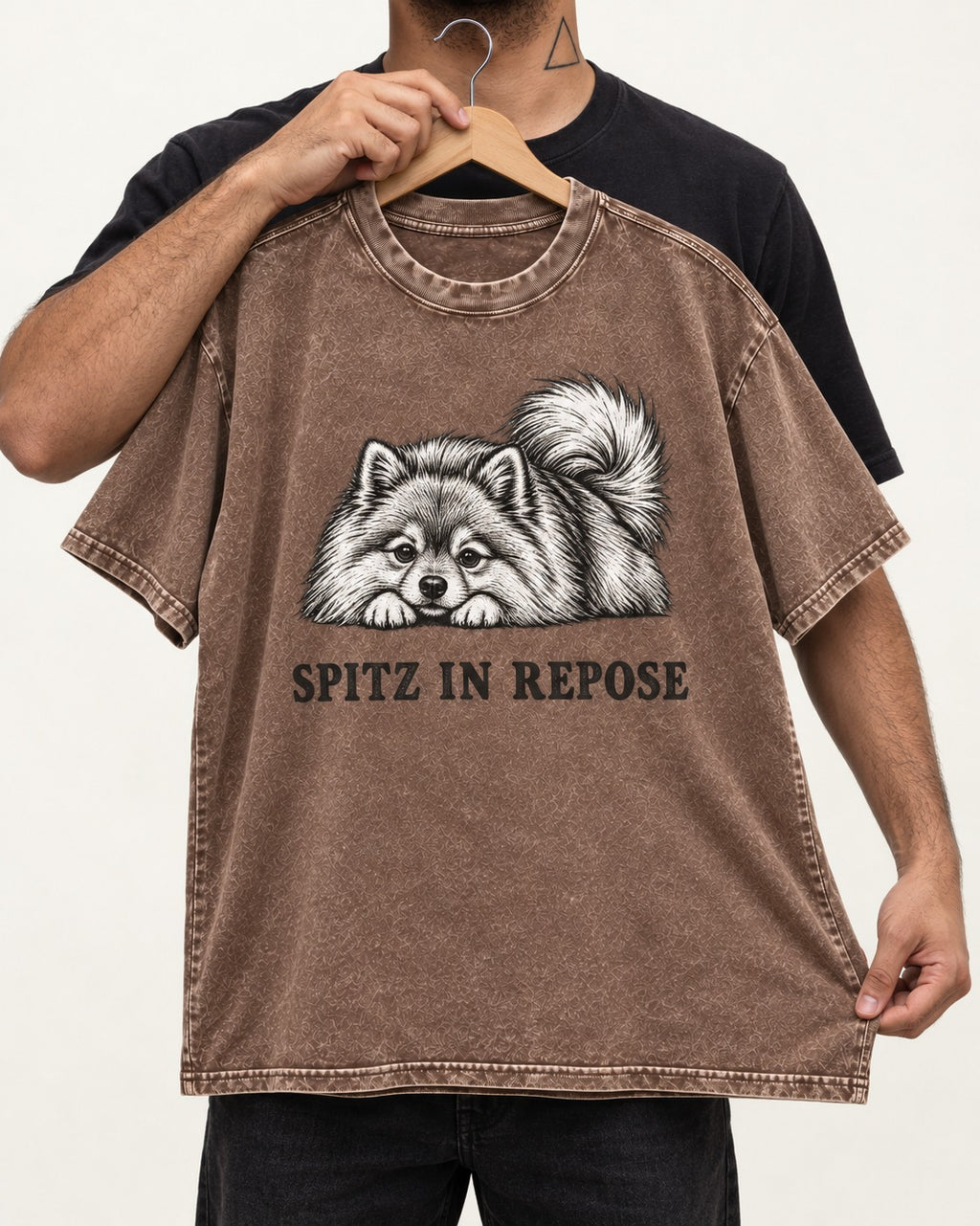 Pomeranian In Repose Washed Tee in Coffee, held up on a hanger
