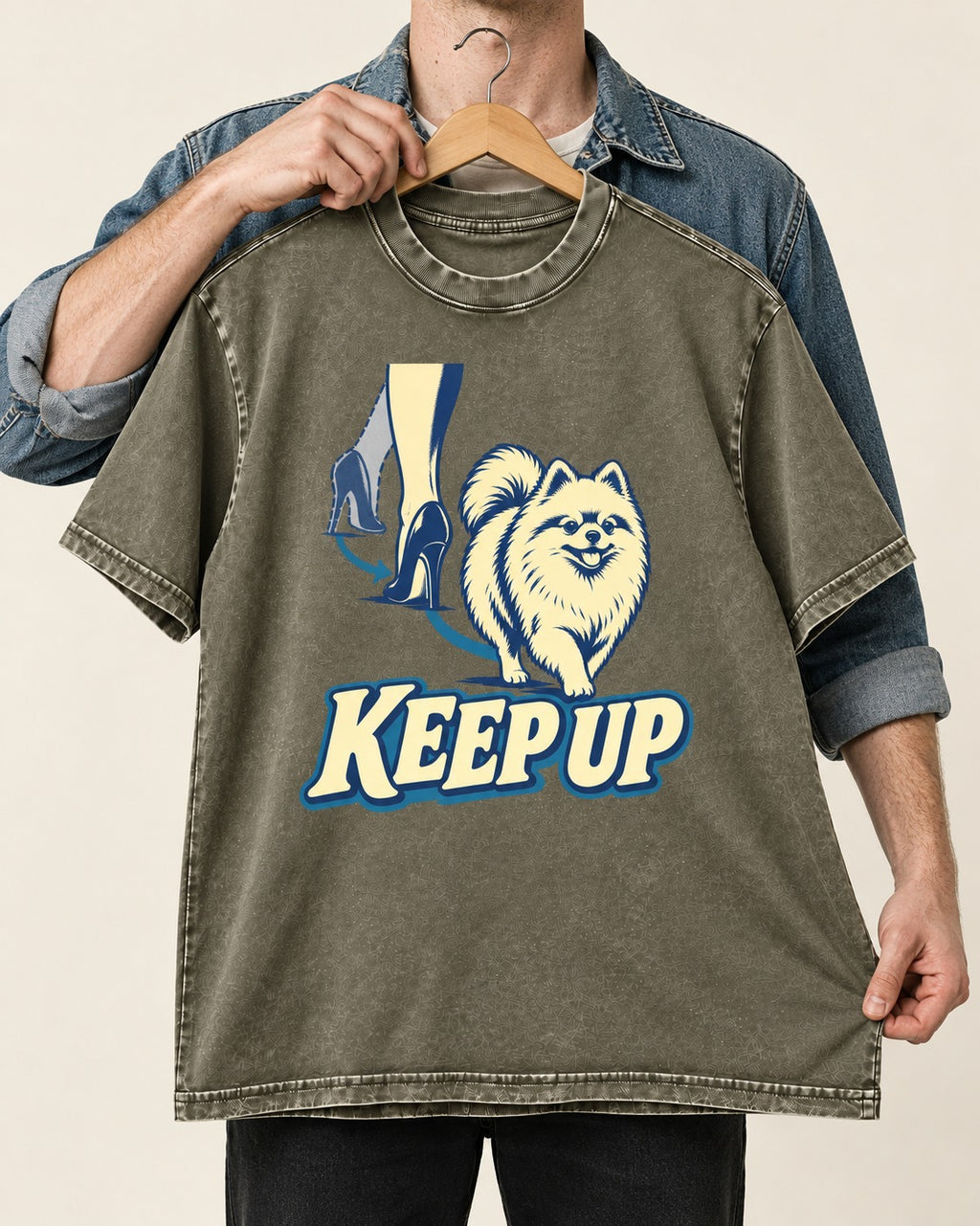Pomeranian Keep Up High Heel Chase Graphic Washed Tee in Army Green, held up on a hanger