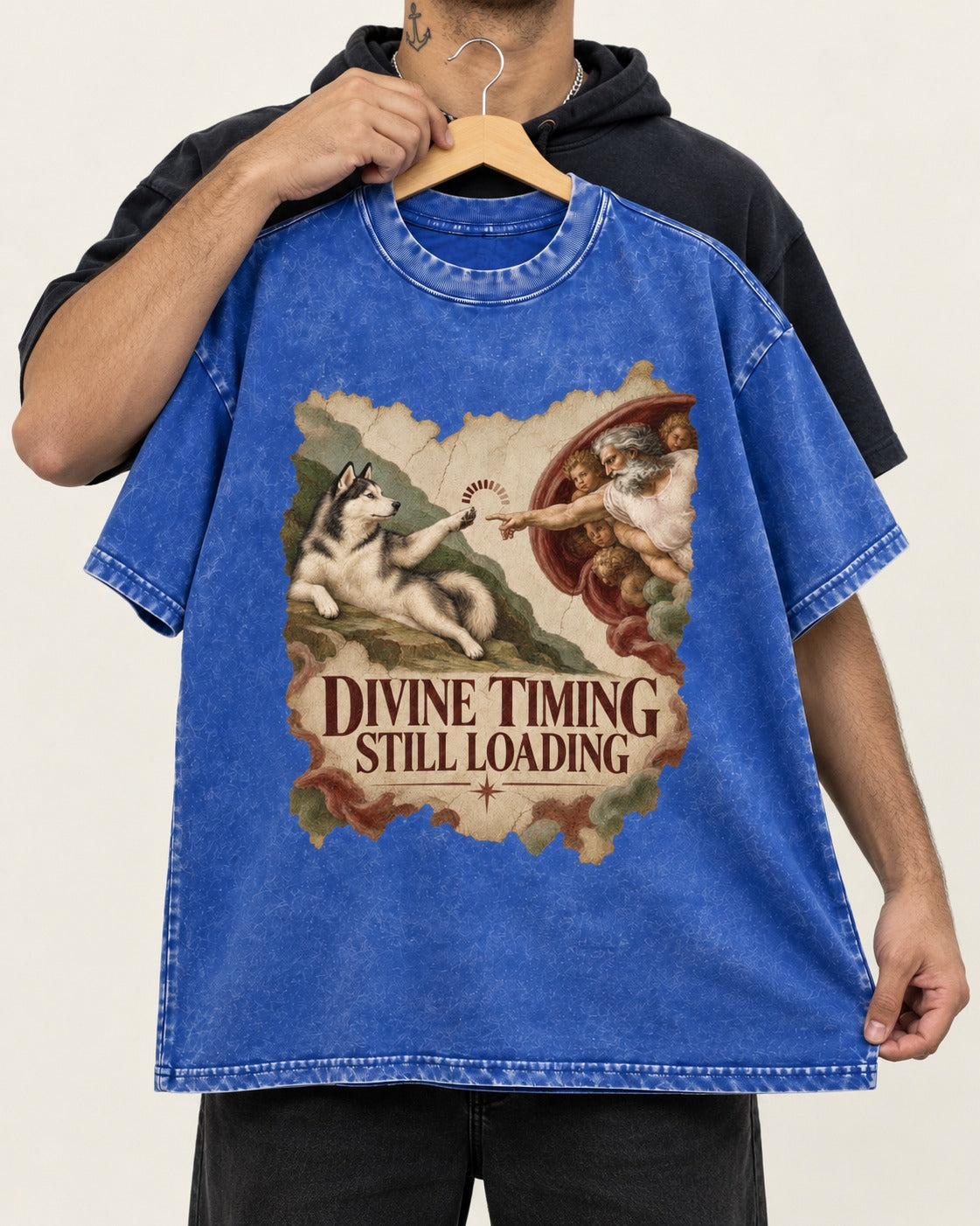 Husky Divine Timing Still Loading Creation Parody Graphic Washed Tee in Royal Blue, held up on a hanger