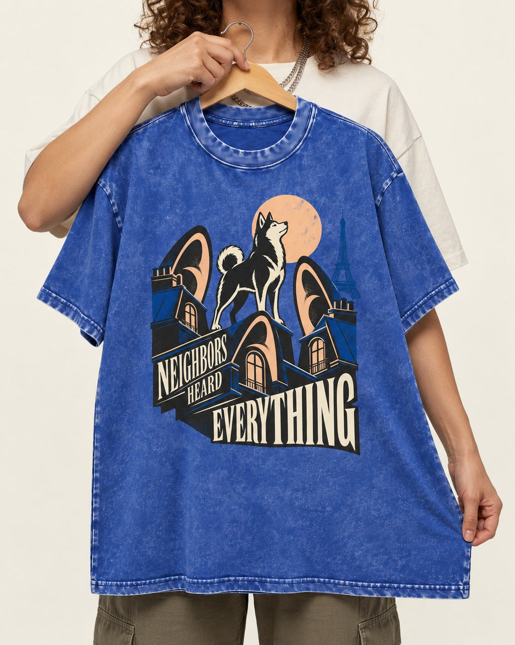 Husky Neighbors Heard Everything Paris Rooftop Graphic Washed Tee in Royal Blue, held up on a hanger