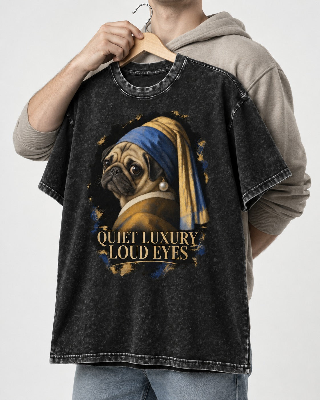 Pug Quiet Luxury Loud Eyes Pearl Portrait Graphic Washed Tee in Black, held up on a hanger