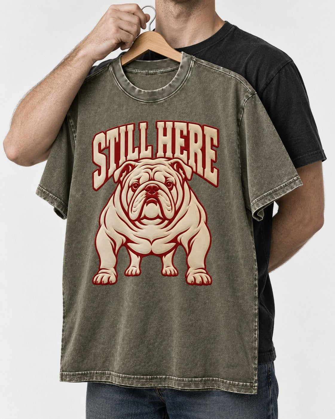 English Bulldog Still Here Collegiate Graphic Washed Tee in Army Green, held up on a hanger