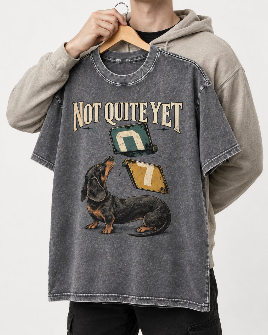 Not Quite Yet Dachshund Washed Tee in Gray, held up on a hanger