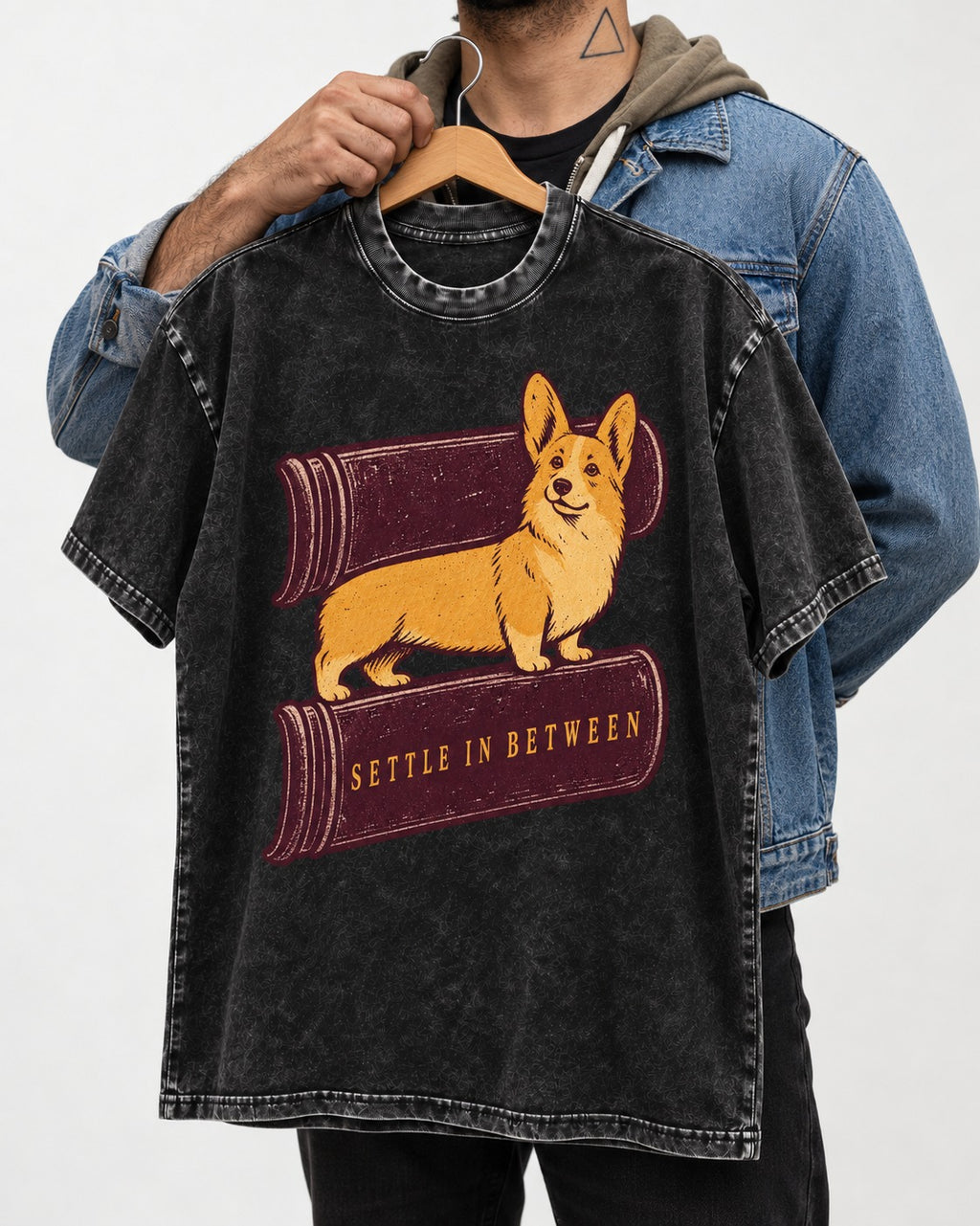 Corgi Settle in Between Washed Tee in Black, held up on a hanger