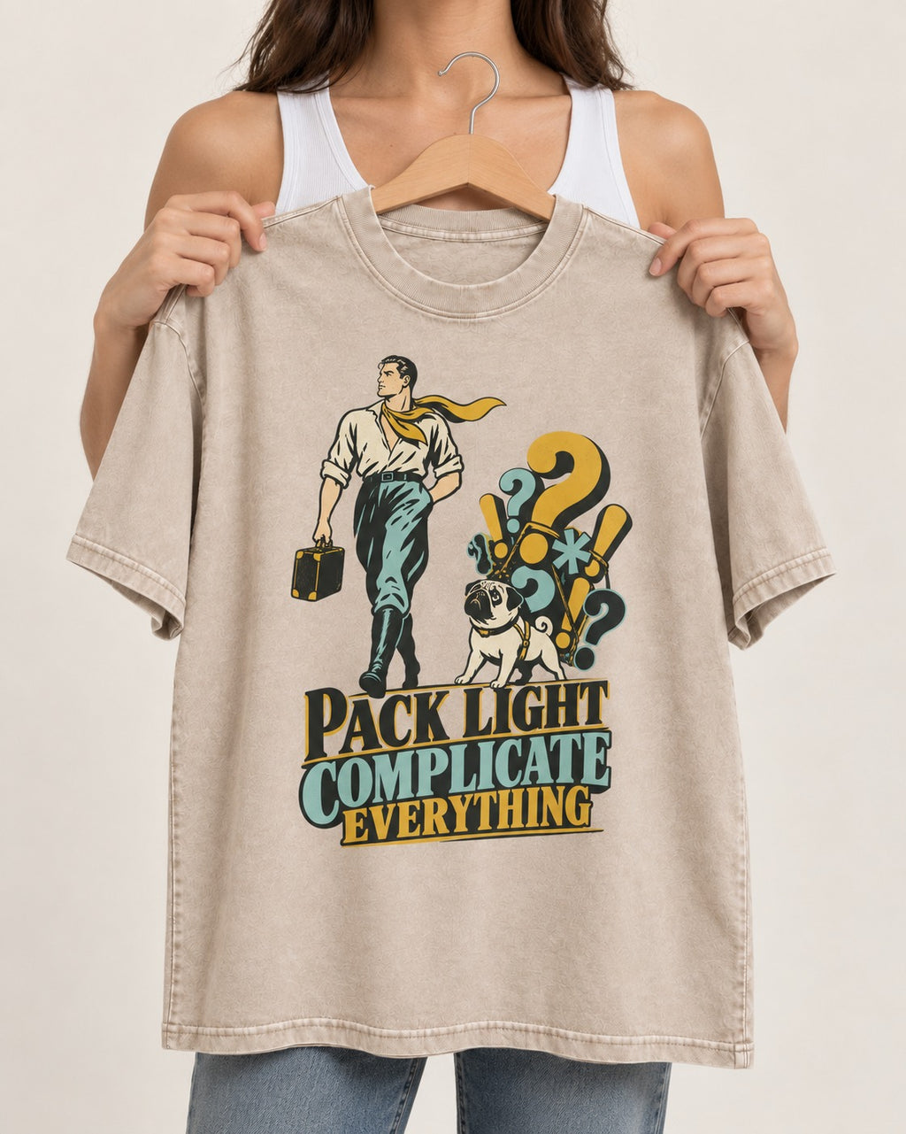 Pug Pack Light Complicate Everything Washed Tee in Apricot, held up on a hanger
