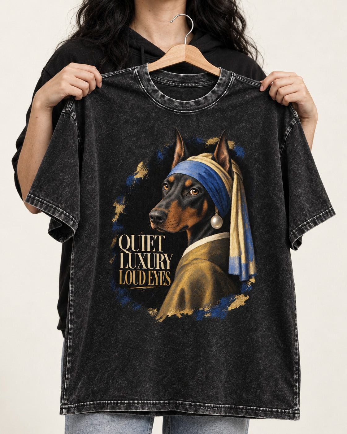 Doberman Quiet Luxury Loud Eyes Pearl Portrait Graphic Washed Tee in Black, held up on a hanger