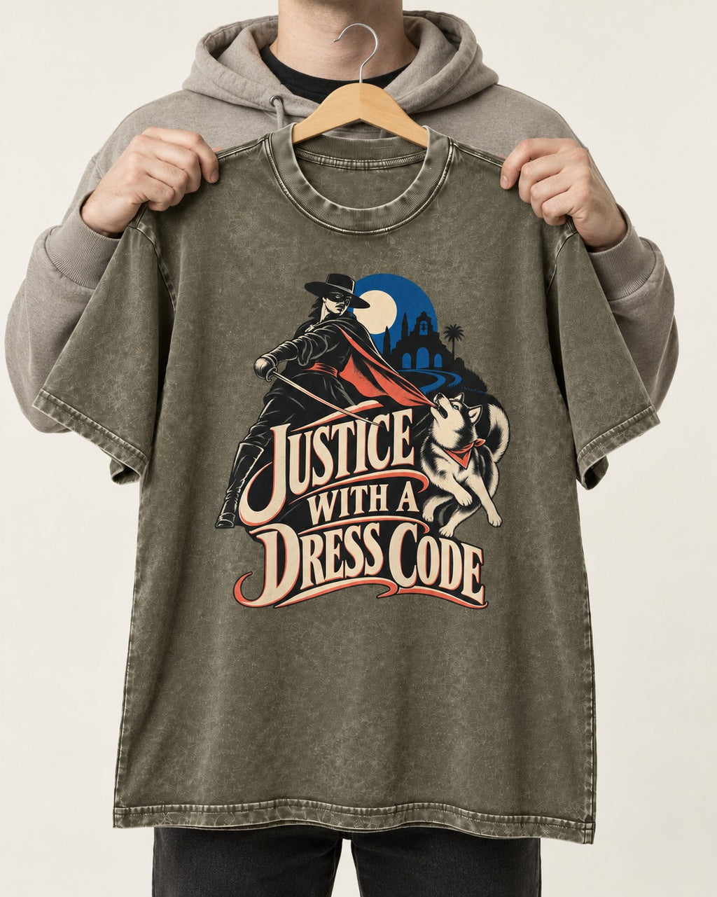 Husky Justice With A Dress Code Masked Swordsman Graphic Washed Tee in Army Green, held up on a hanger