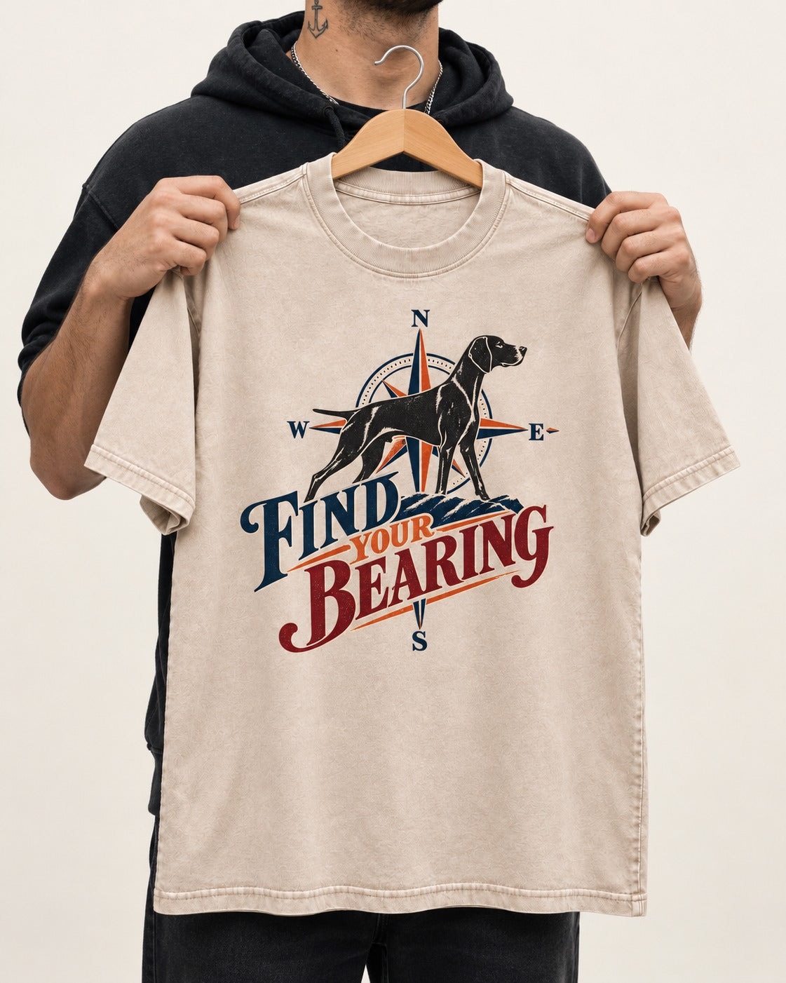 Find Your Bearing German Shorthaired Pointer Washed Tee in Apricot, held up on a hanger