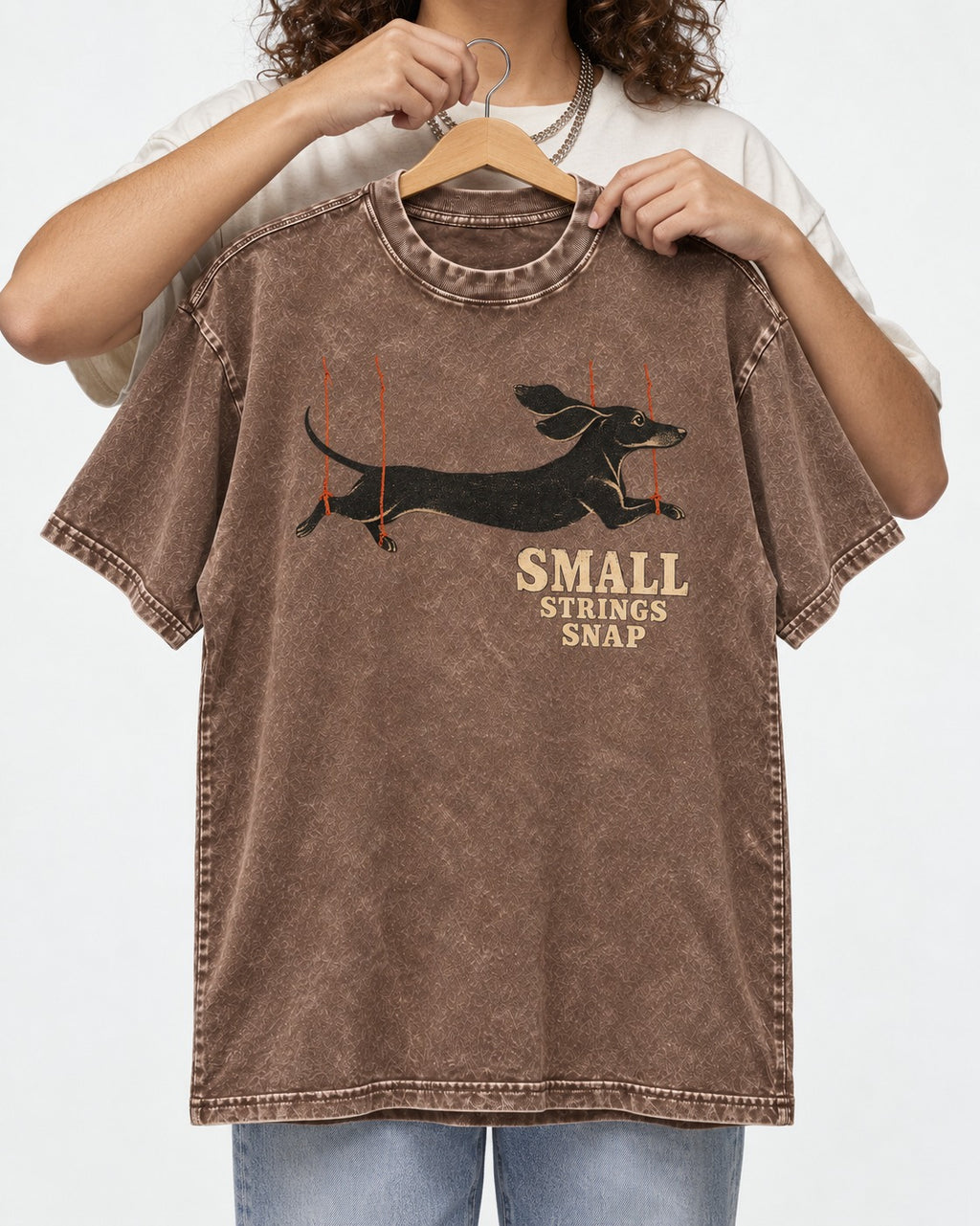 Dachshund Small Strings Snap Marionette Graphic Washed Tee in Coffee, held up on a hanger