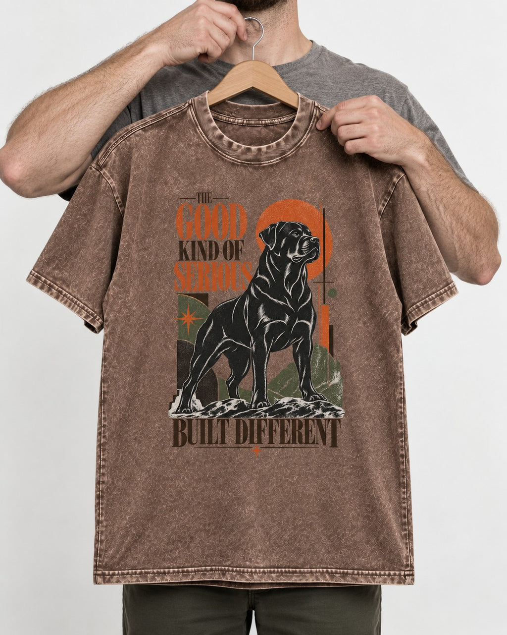 Rottweiler Built Different Washed Tee in Coffee, held up on a hanger