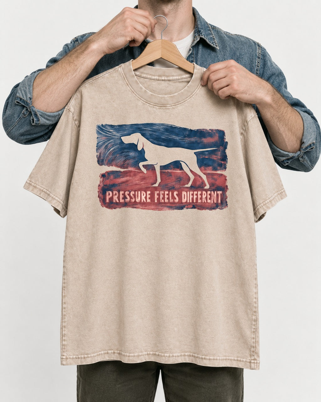 German Shorthaired Pointer Pressure Feels Different Monotype Graphic Washed Tee in Apricot, held up on a hanger