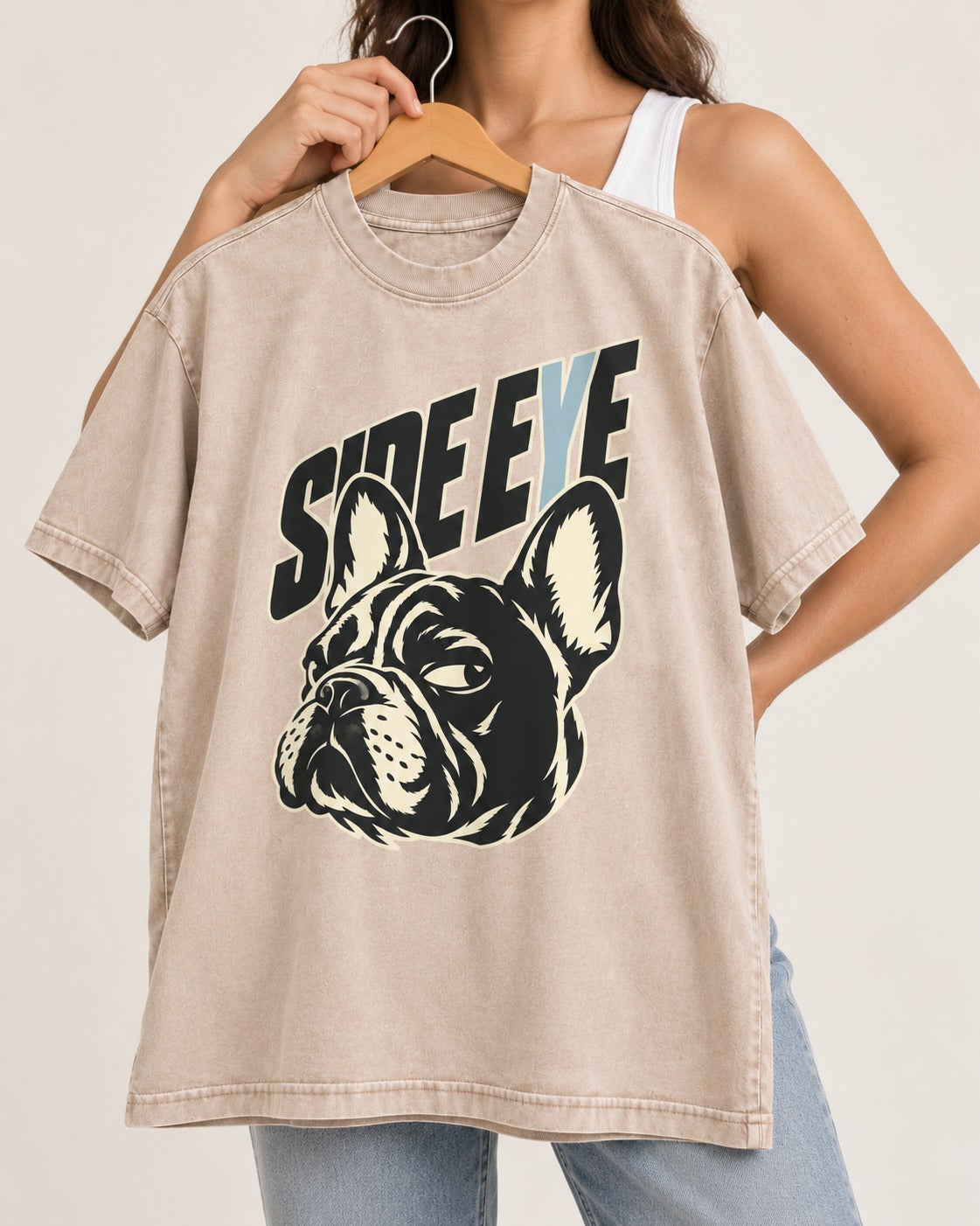 Frenchie Side Eye Portrait Graphic Washed Tee in Apricot, held up on a hanger