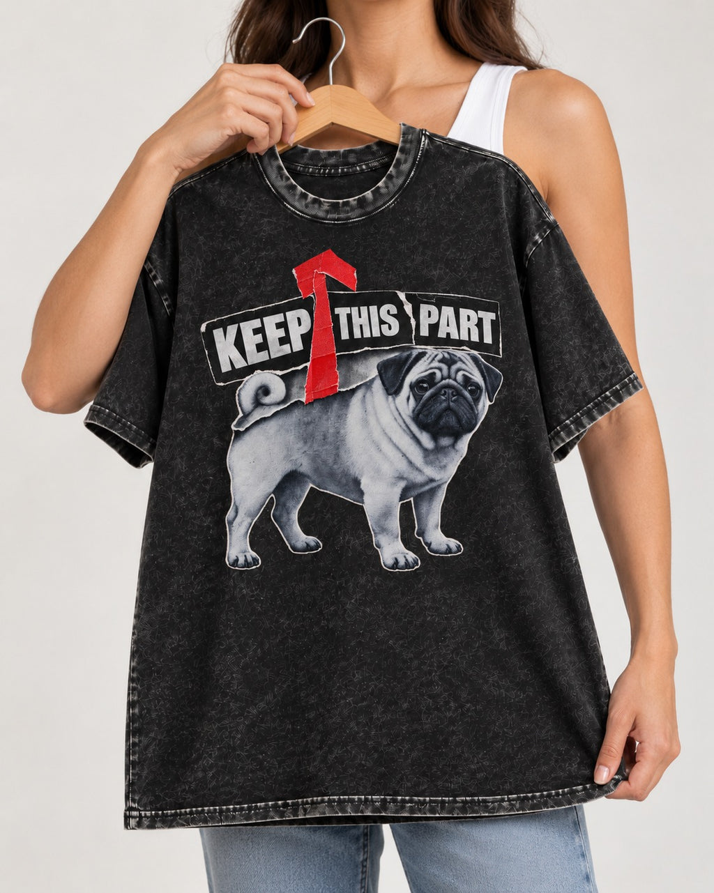 Pug Keep This Part Tape Arrow Graphic Washed Tee in Black, held up on a hanger