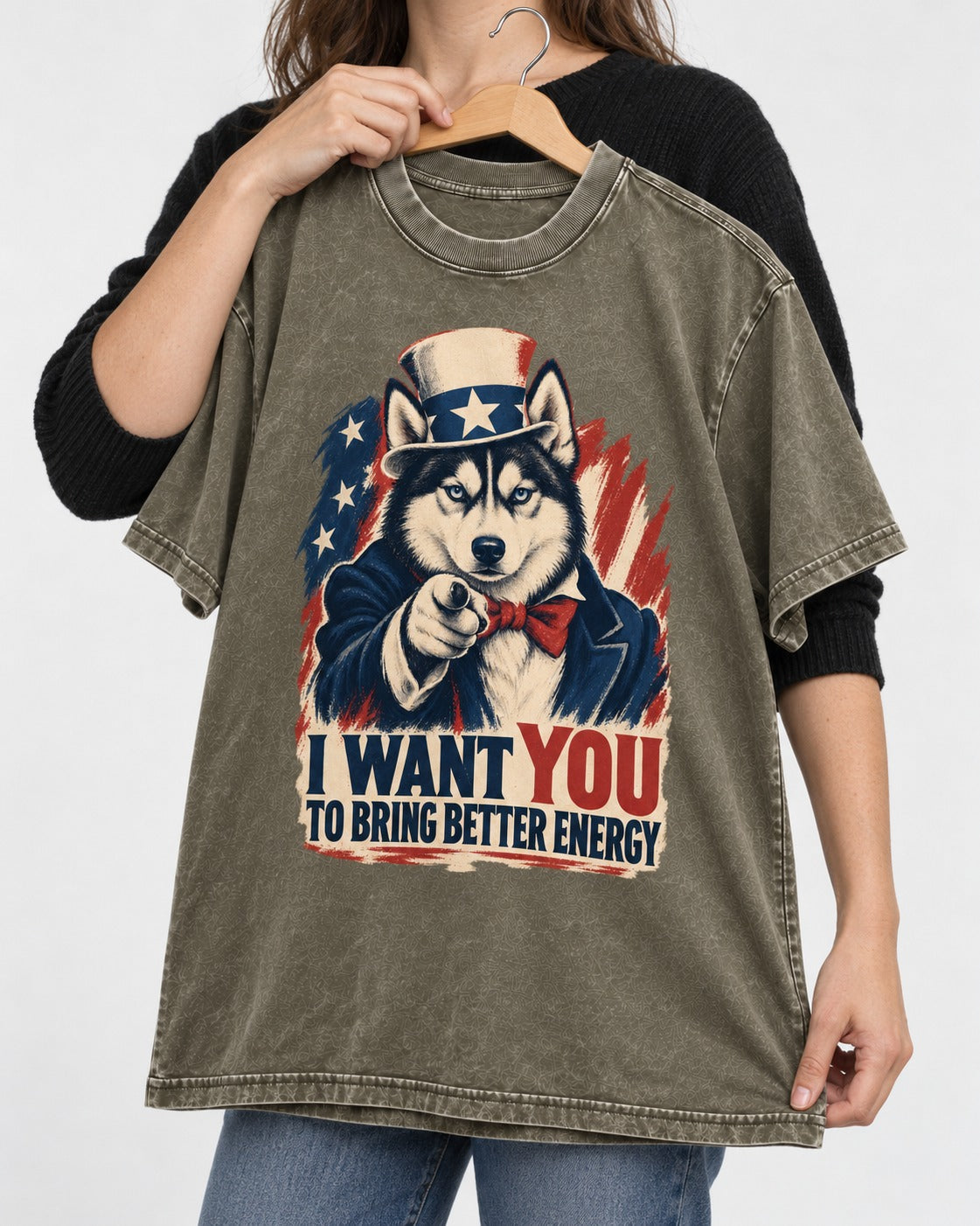 Husky I Want You to Bring Better Energy Patriotic Poster Graphic Washed Tee in Army Green, held up on a hanger