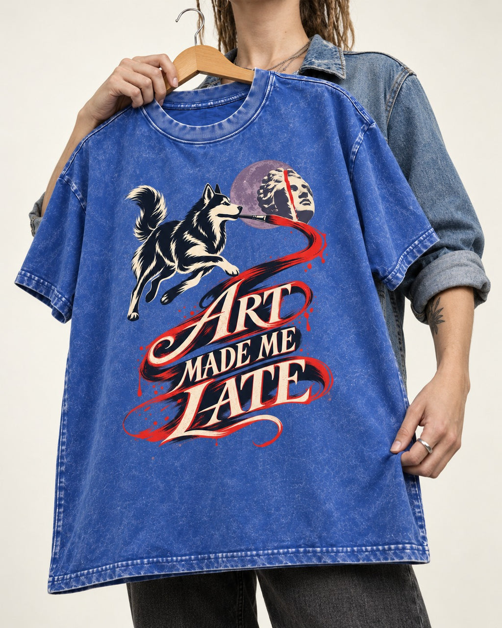 Husky Art Made Me Late Paintbrush Graphic Washed Tee in Royal Blue, held up on a hanger
