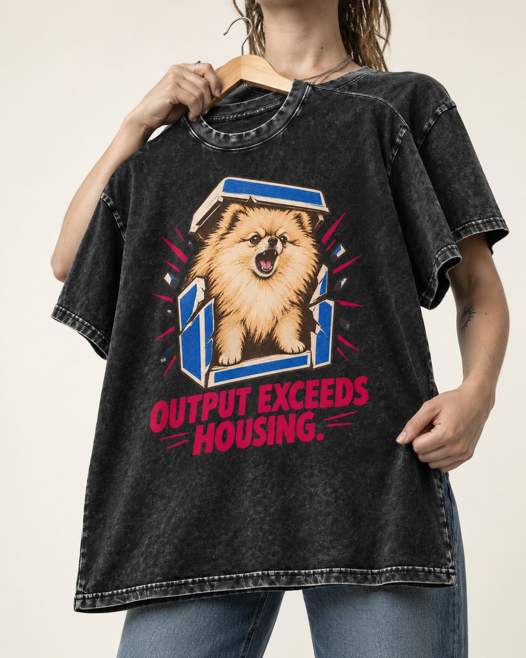 Pomeranian Output Exceeds Housing Bark Compression Graphic Washed Tee in Black, held up on a hanger