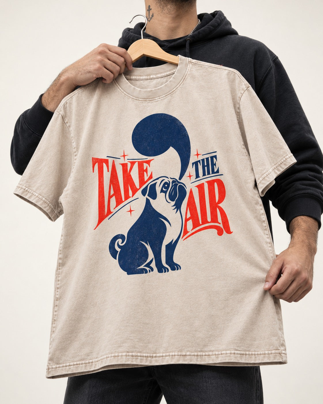 Pug Take the Air Washed Tee in Apricot, held up on a hanger
