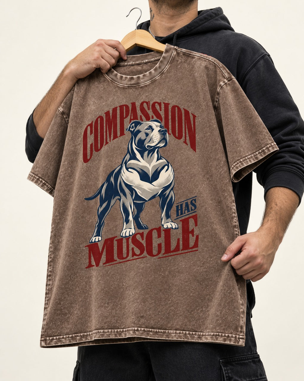 Pitbull Compassion Has Muscle Washed Tee in Coffee, held up on a hanger