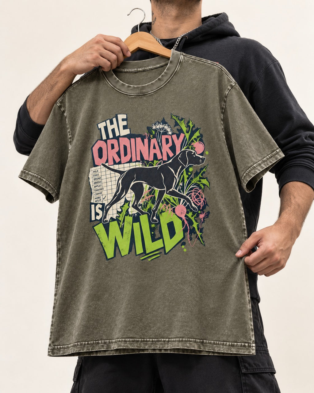 German Shorthaired Pointer The Ordinary Is Wild Grocery List Graphic Washed Tee in Army Green, held up on a hanger