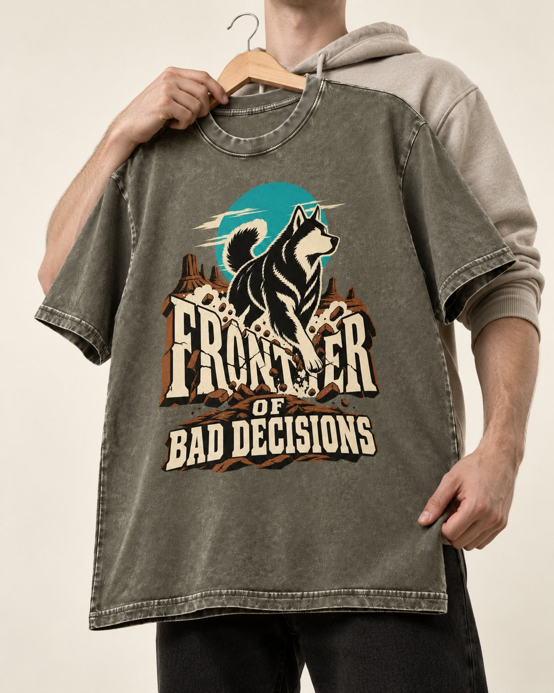 Husky Frontier of Bad Decisions Desert Graphic Washed Tee in Army Green, held up on a hanger