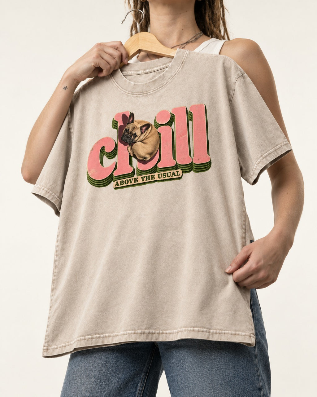 Frenchie Chill Washed Tee in Apricot, held up on a hanger