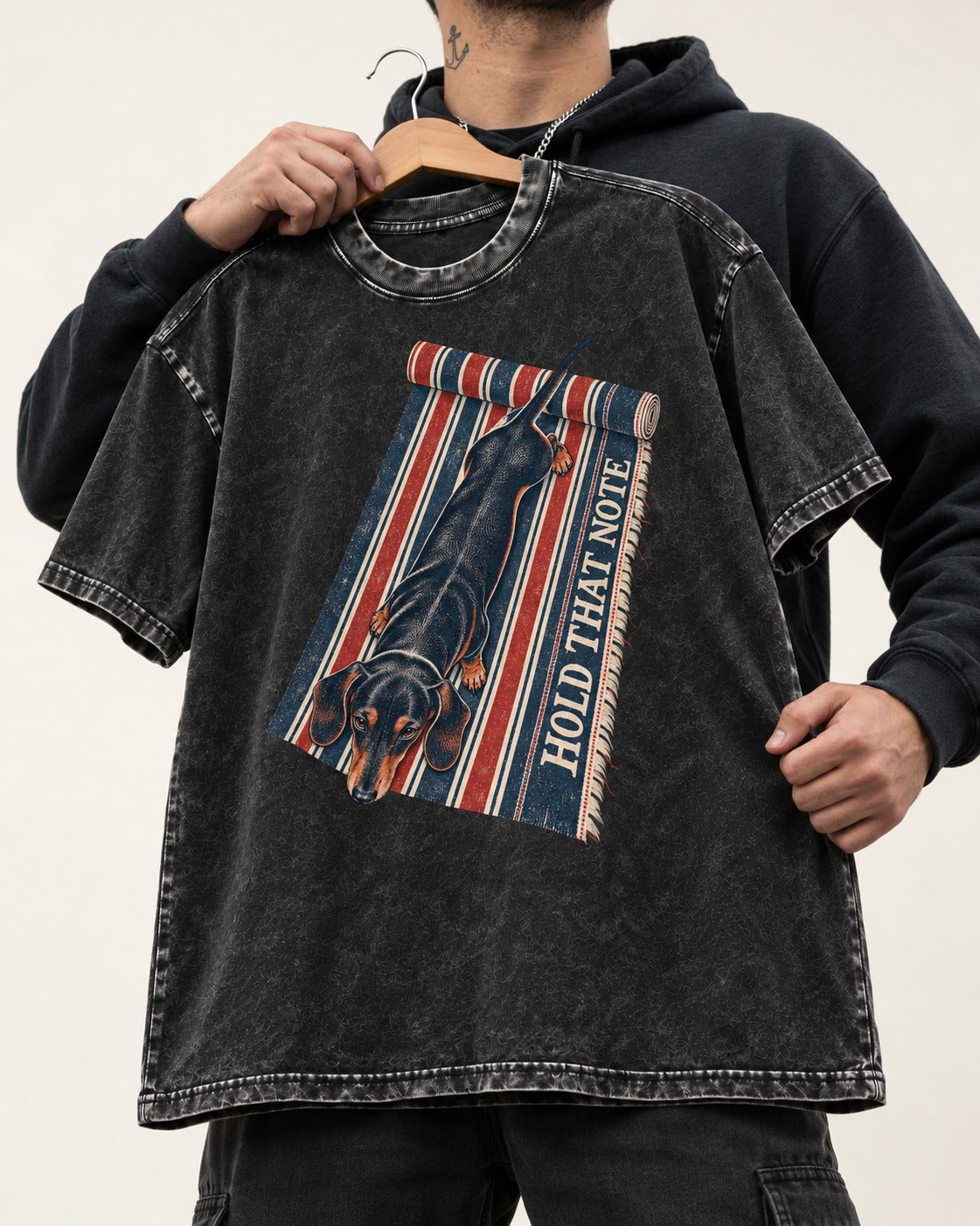 Dachshund Hold That Note Striped Rug Graphic Washed Tee in Black, held up on a hanger