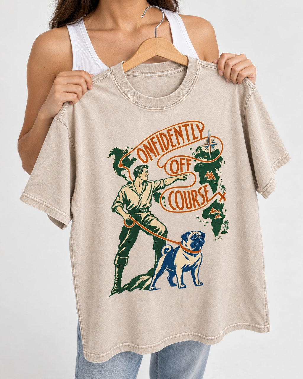Pug Confidently Off Course Washed Tee in Apricot, held up on a hanger