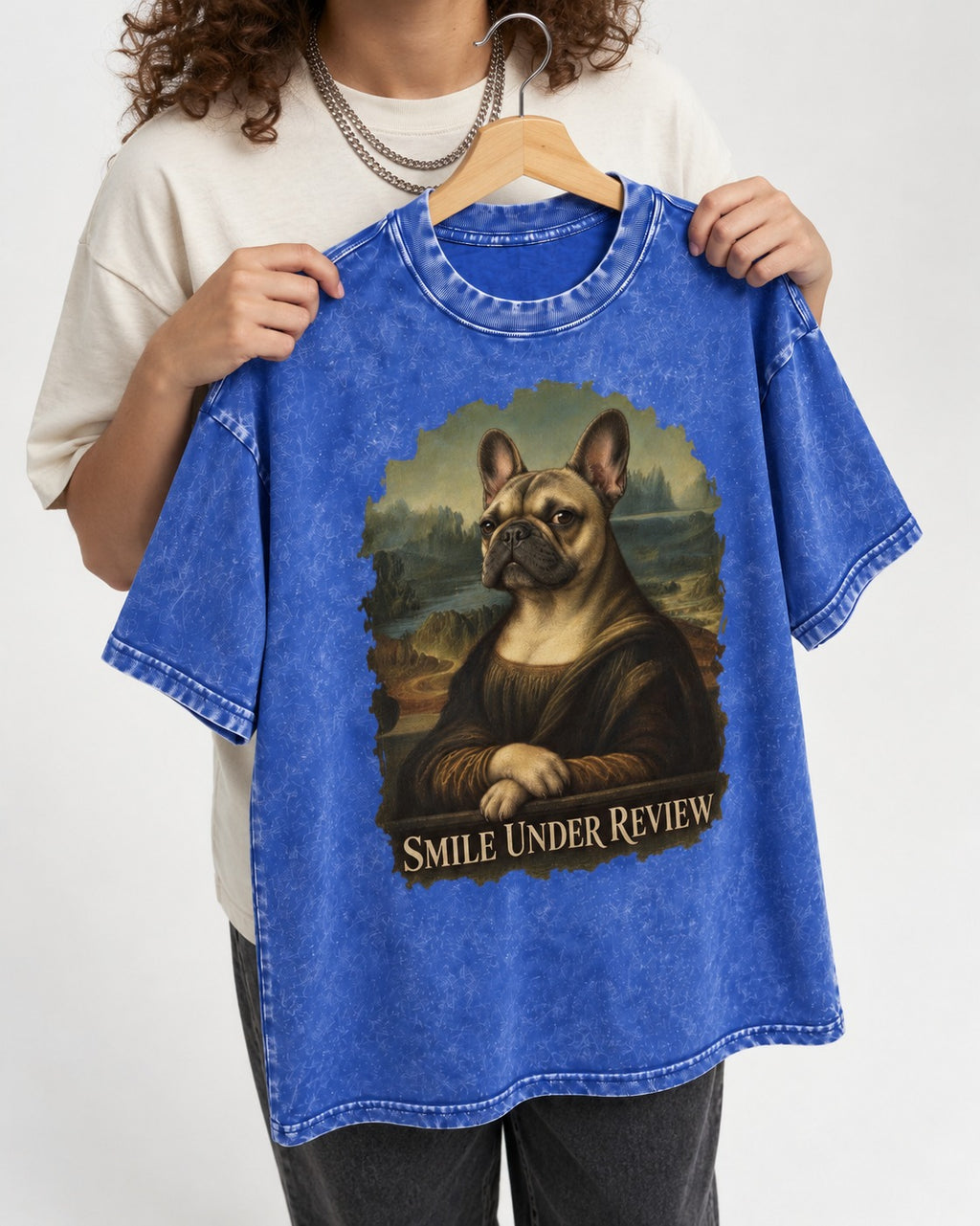 Frenchie Smile Under Review Renaissance Portrait Washed Tee in Royal Blue, held up on a hanger