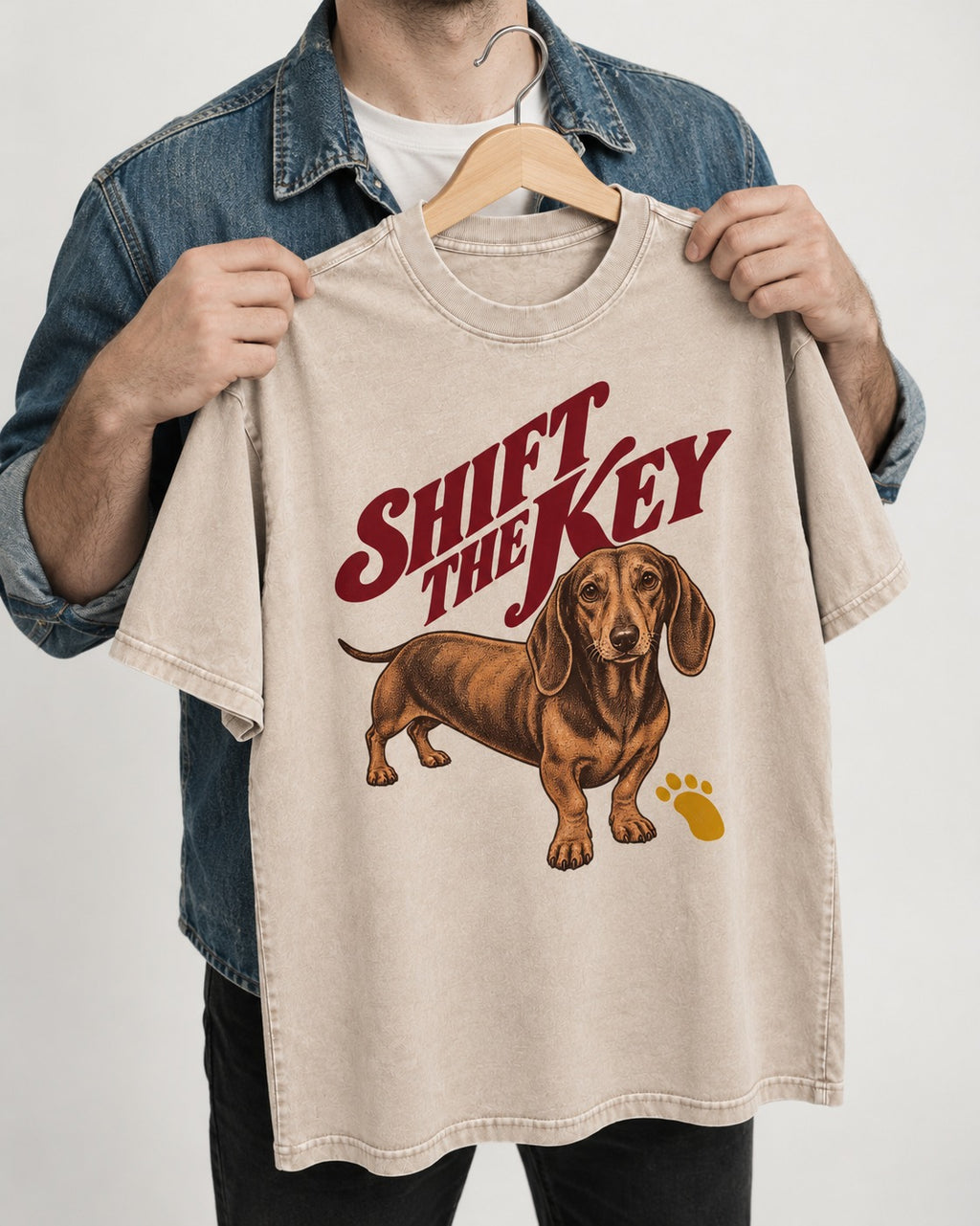 Dachshund Shift The Key Pawprint Graphic Washed Tee in Apricot, held up on a hanger