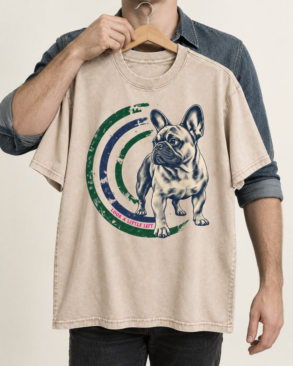 Frenchie Look a Little Left Orbit Graphic Washed Tee in Apricot, held up on a hanger