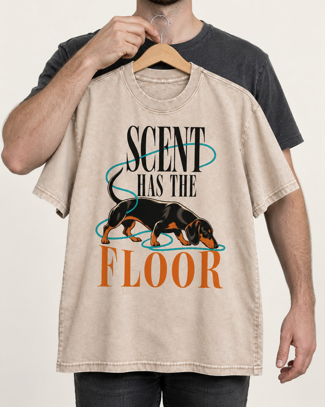 Dachshund Scent Has the Floor Washed Tee in Apricot, held up on a hanger