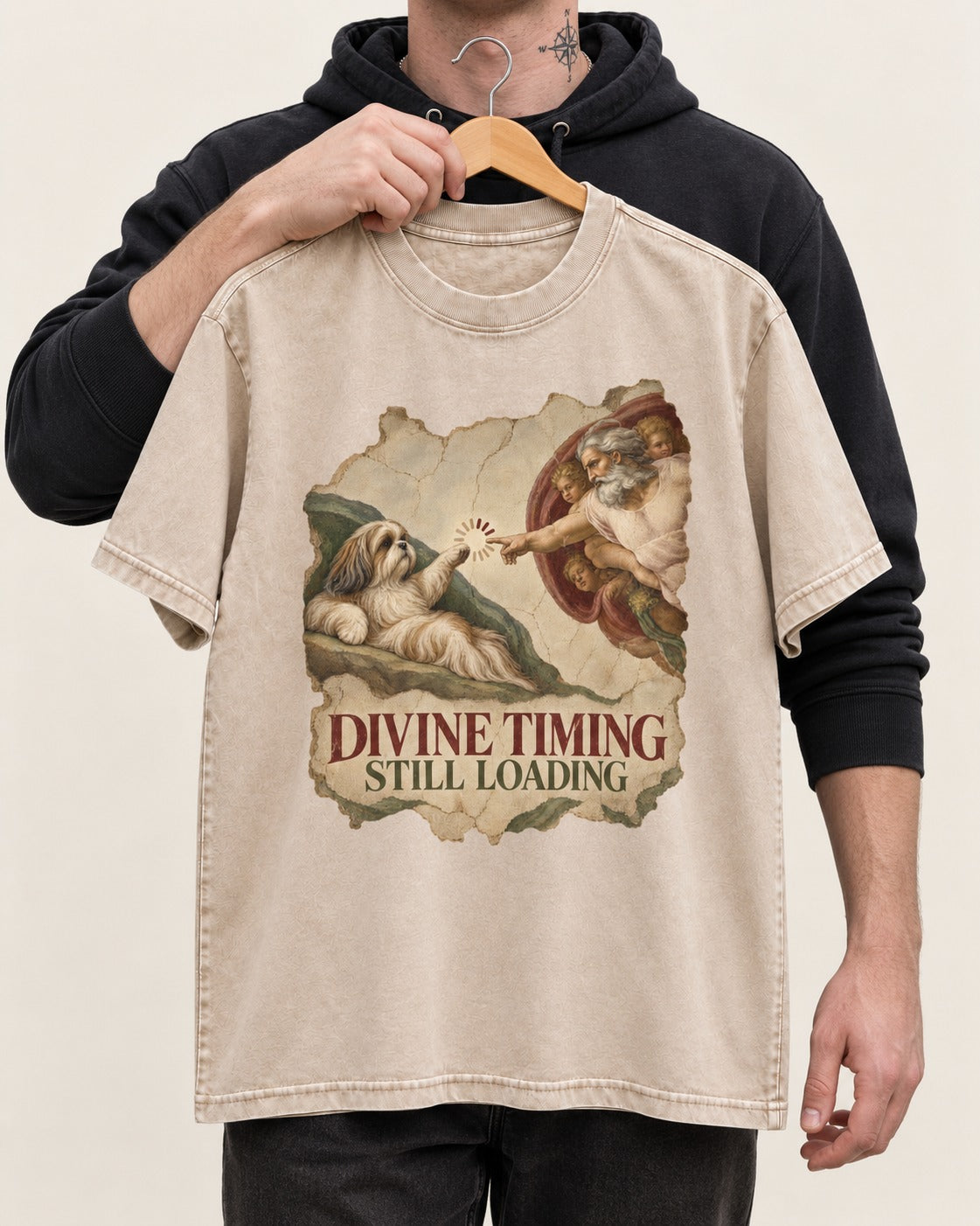 Shih Tzu Divine Timing Still Loading Renaissance Parody Graphic Washed Tee in Apricot, held up on a hanger