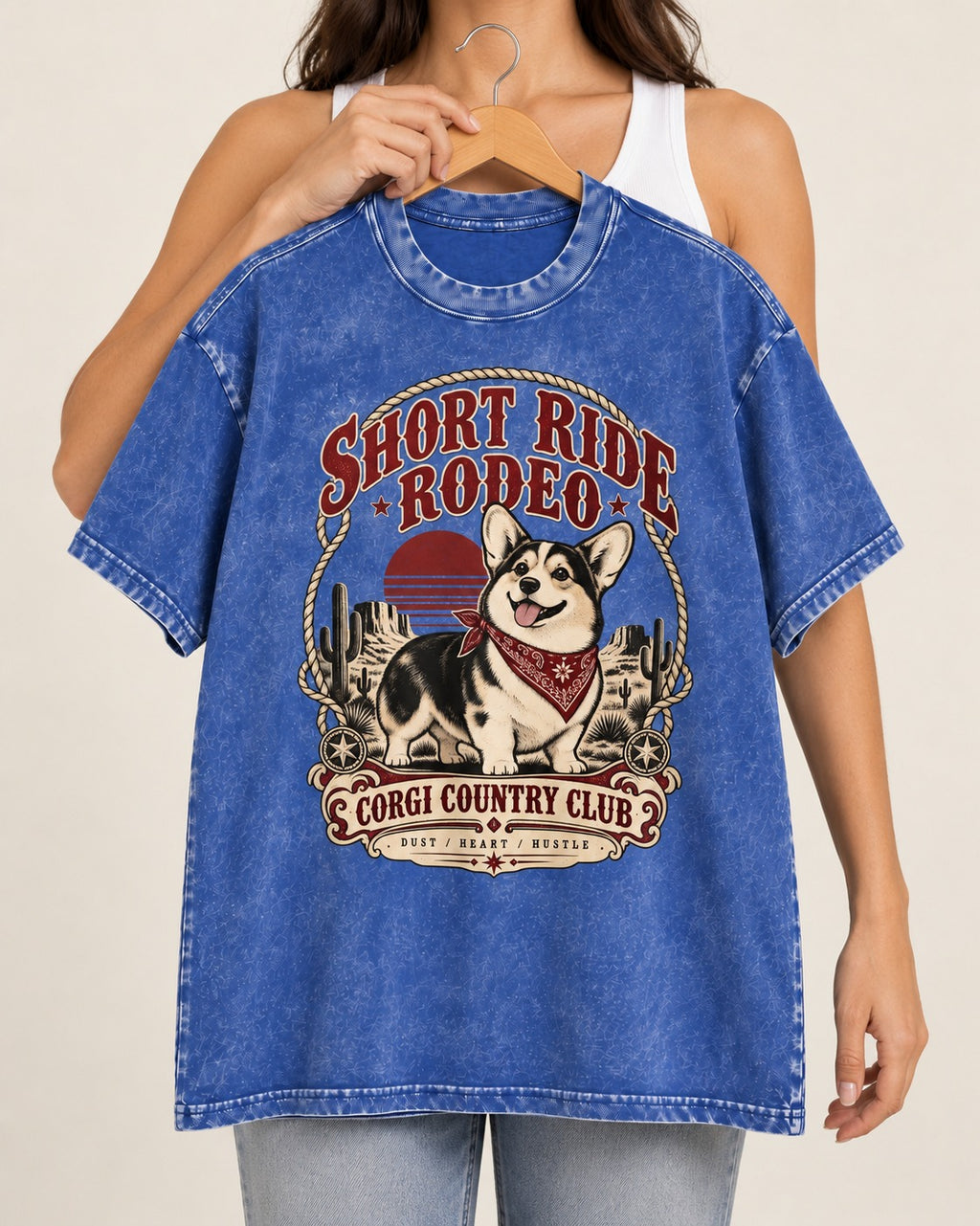 Corgi Short Ride Rodeo Country Club Badge Washed Tee in Royal Blue, held up on a hanger