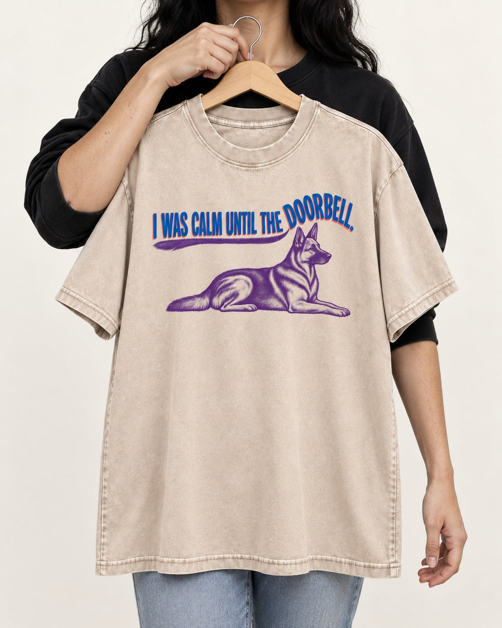 German Shepherd Dog Calm Until the Doorbell Washed Tee in Apricot, held up on a hanger