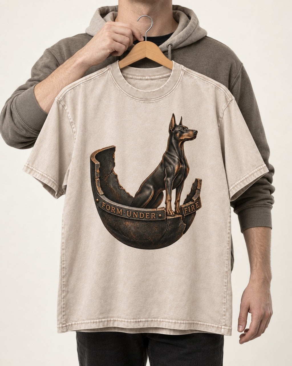 Doberman Form Under Fire Broken Shell Graphic Washed Tee in Apricot, held up on a hanger