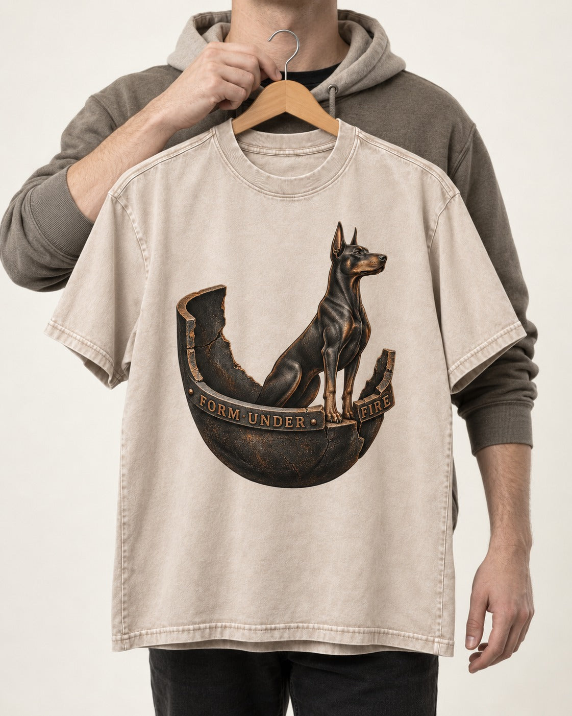 Doberman Form Under Fire Broken Shell Graphic Washed Tee in Apricot, held up on a hanger