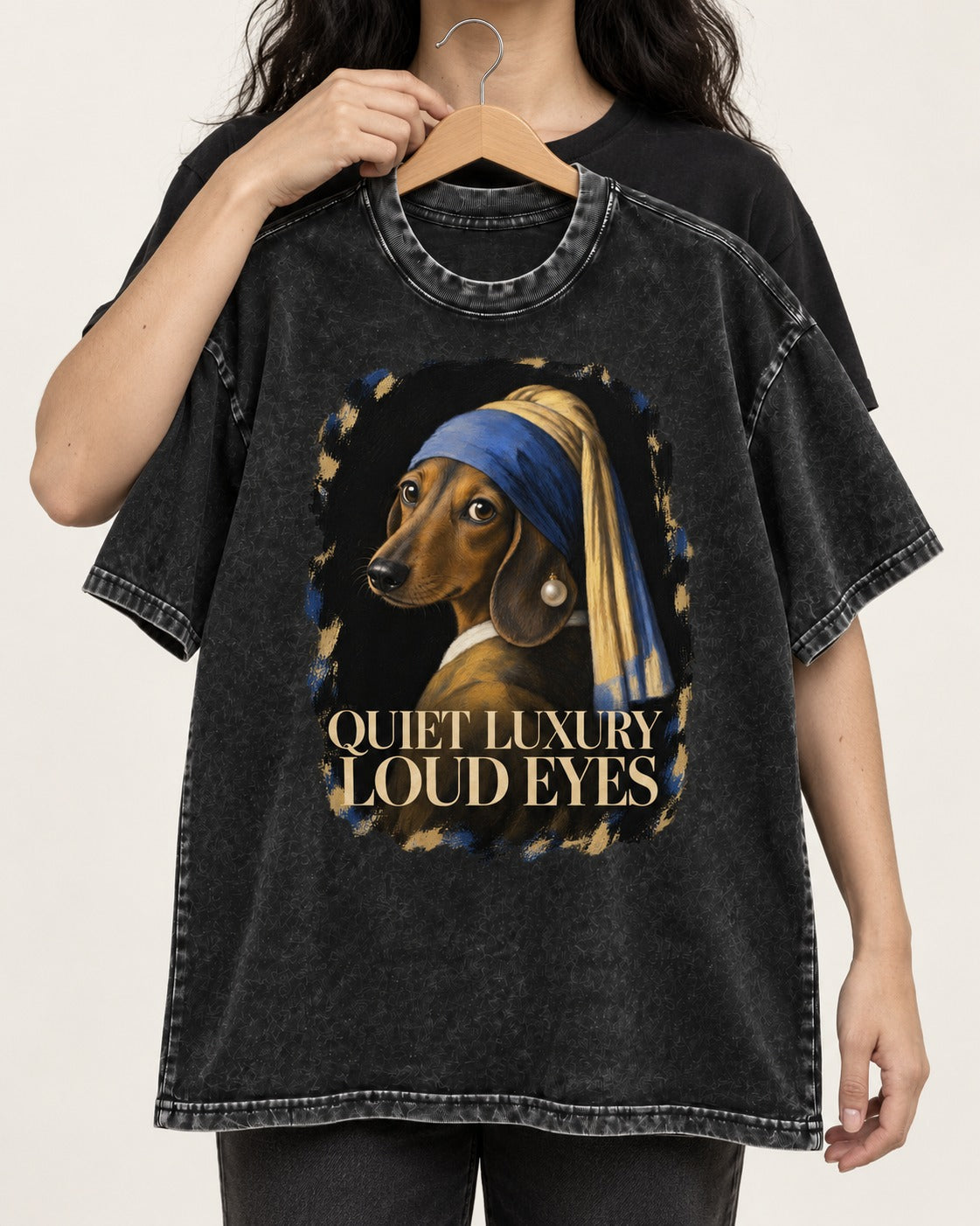Dachshund Quiet Luxury Loud Eyes Pearl Portrait Graphic Washed Tee in Black, held up on a hanger