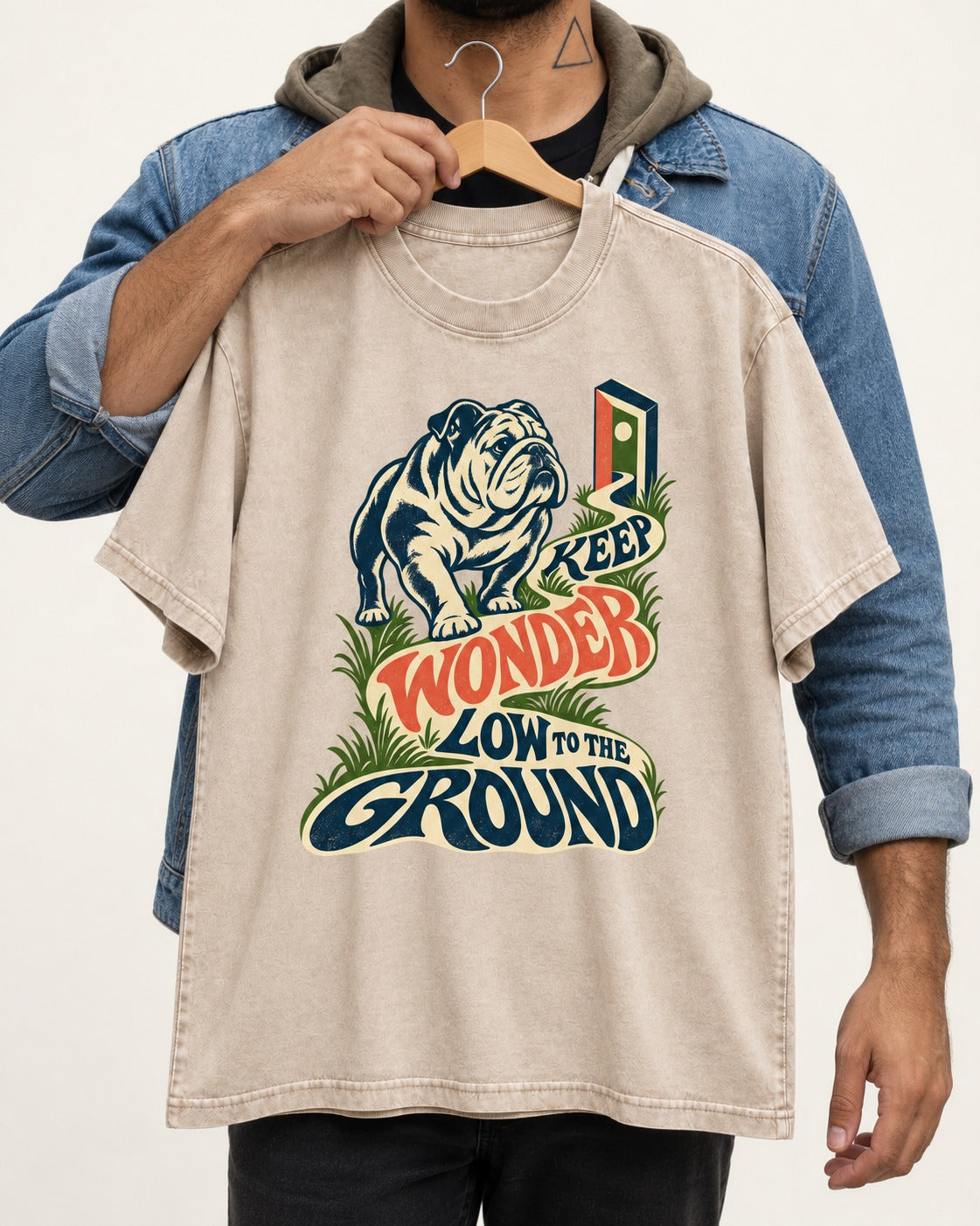 Keep Wonder Low to the Ground English Bulldog Graphic Washed Tee in Apricot, held up on a hanger