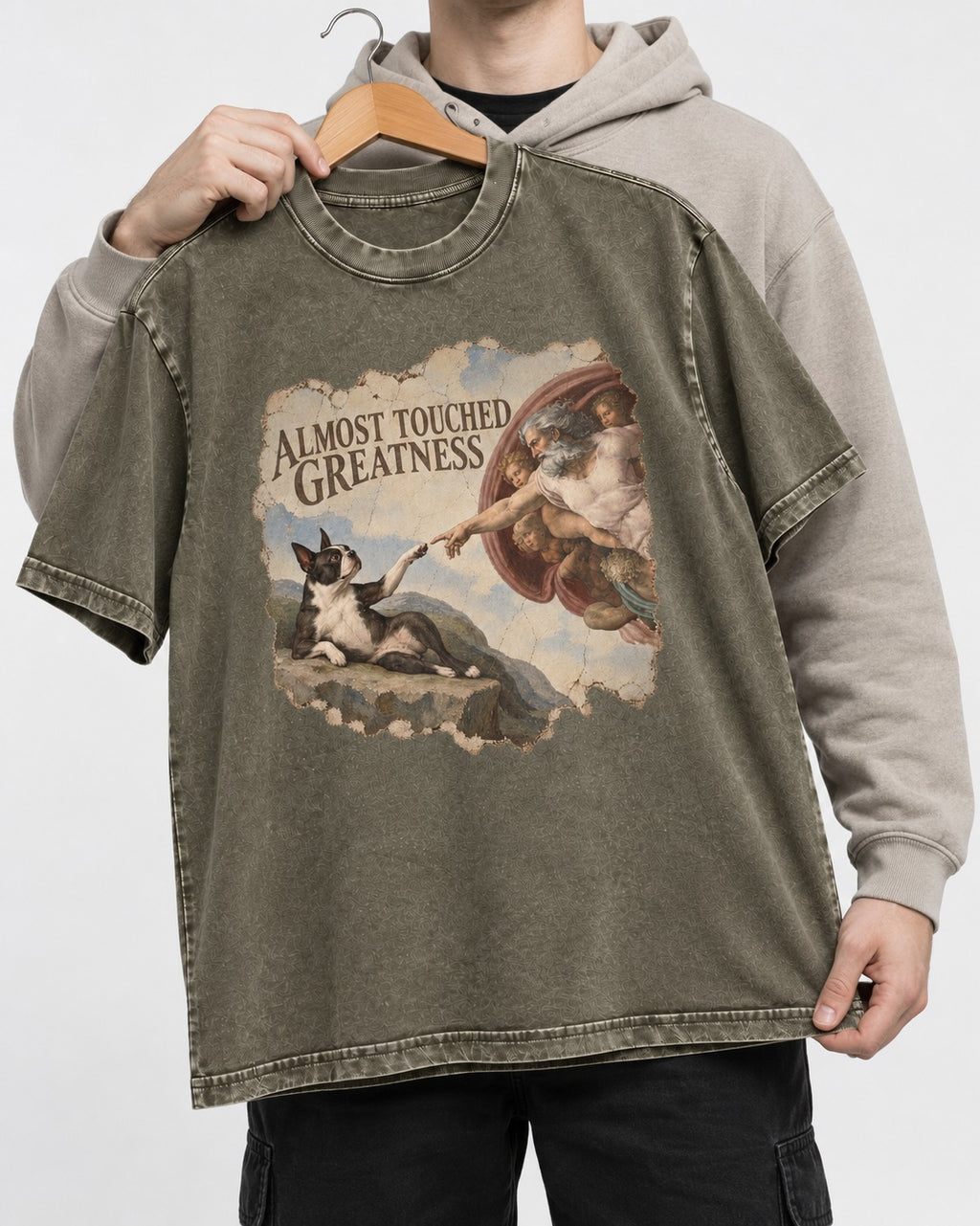 Almost Touched Greatness Boston Terrier Renaissance Parody Washed Tee in Army Green, held up on a hanger